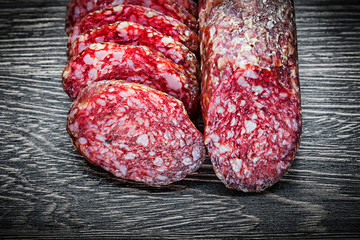 Sliced salami on wooden board top view food concept