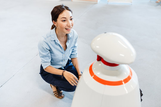 Young Adult Woman Looking At The Toy Robot At The Exhibition