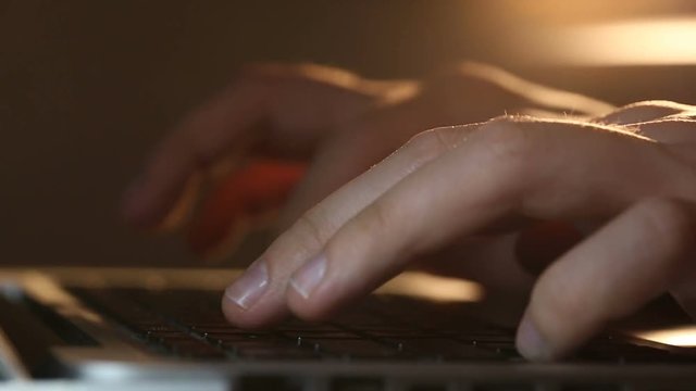 Extremely close-up refocusing shot of programmer's hands typing commands on laptop keyboard. Developer using the keypad for developing application.