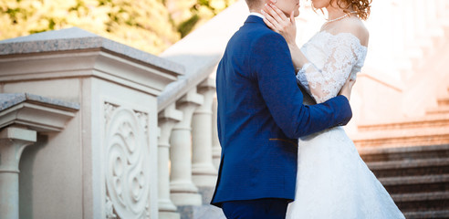 Portrait of happy bride and groom near columns