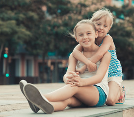 Two smiling little girls embracing