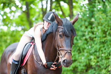Fototapeta premium Young teenage lady-equestrian embracing her favorite frend-chestnut horse.