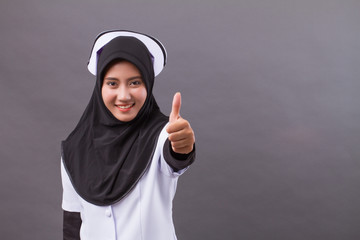 successful muslim nurse giving thumb up