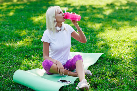 Photo of sports girl drinking from bottle