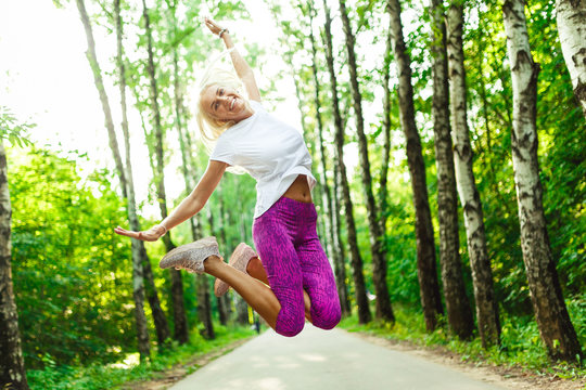 Picture of sports woman jumping in park