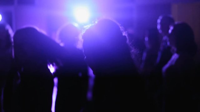 Dancing silhouettes of young woman in a nightclub