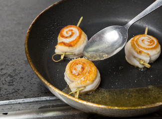 Fresh organic black sole fish frying in black stainless steel non stick pan in a kitchen environment.