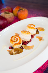 pan fried fresh organic black sole fish, served onto a bed of confit beetroot and shallots on a white plate in a stylish pink restaurant setting.