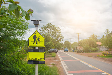 Yellow sign school zone symbol in the countryside . - 175342322