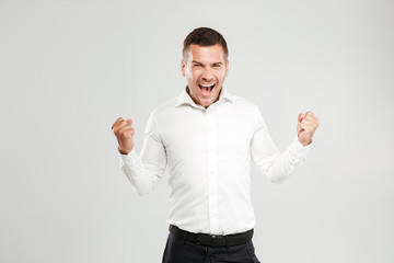 Fototapeta premium Screaming emotional young man make winner gesture.
