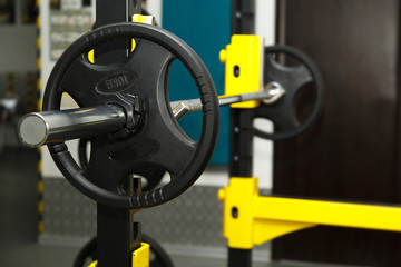 Gym. Gymnasium with sports equipment. Barbells, dumbbells - equipment to work on muscle mass. Fitness club weight training equipment gym. Barbell ready to workout, indoors, shallow.