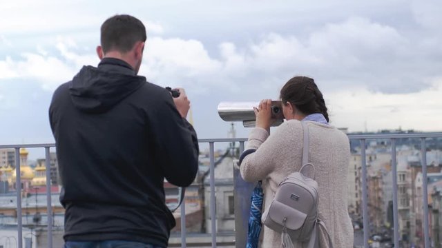 Woman travel and viewing with tourist binocular in Saint Petersburg and her friend takes photo of her. 3840x2160