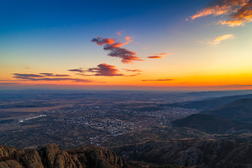 Dramatic sunset over the mountain hills and Sliven city, aerial panoramic view