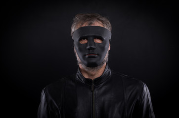 Mystery man holding black  mask. Anonymous social masking concept.