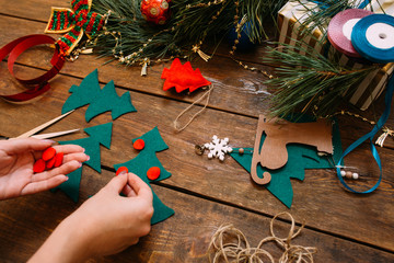 Holiday preparation. Christmas and New Year. Unrecognizable woman decorating green felt fir tree on...