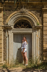 Fototapeta na wymiar Young beautiful girl at the old door near the Villa Pamphili in Rome, Italy