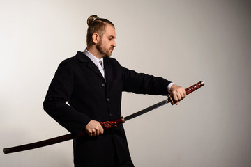 Male businessmanpulls out a sword of Japanese samurai