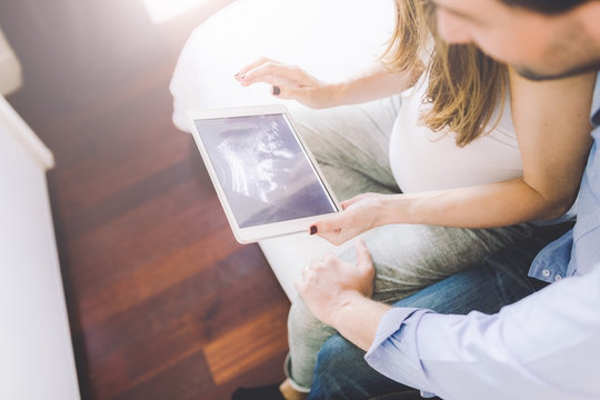 Couple looking at an ultrasound on digital tablet