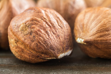 Raw brown hazelnut on wooden planks, macro image