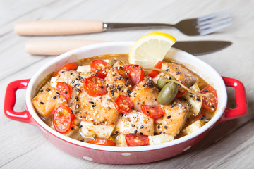 Salmon baked with sesame, tomatoes and zucchini. Close-up. Selective focus.