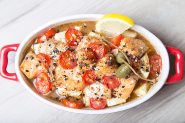 Salmon baked with sesame, tomatoes and zucchini. Close-up. Selective focus.