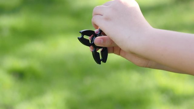 Cute Asian child  playing  fidget spinner on nature background 