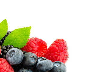 Close-up arrangement with mixed, assorted berries including blackberries, strawberry, blueberry and raspberries and fresh leaf isolated on white. Colorful, healthy concept. Black, blue, red, green