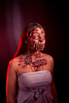 Zombie girl with sad eyes on a red black background, image on Halloween