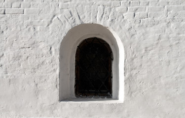 Fototapeta na wymiar Old monastery window and white wall