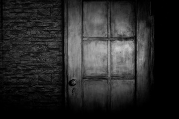 Grungy door on the brick wall, black and white