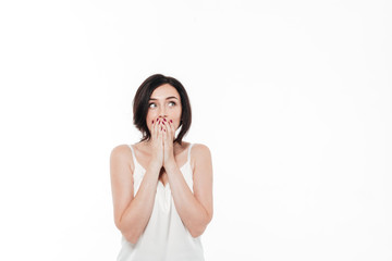 Fototapeta premium Portrait of a surprised brunette woman covering mouth