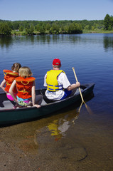 Dad and kids launching a canoe