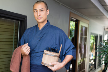Onsen series: Asian man holding wooden bucket in ryokan