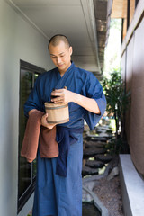 Onsen series: Asian man holding wooden bucket in ryokan