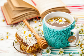 Honeycomb and chamomile tea on white