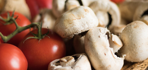 White mushrooms champignons and red organic tomatoes are popular ingredients of a healthy vegetarian diet. 