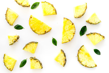Pinneapple slices and leaves pattern on white background top view
