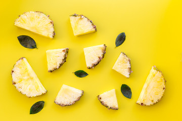 Exotic fruits pattern. Pinneapple slices on yellow background top view copyspace