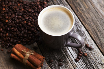 coffee cup with coffee beans on wood background