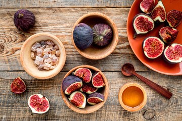 Make jam. Fresh blue figs in bowl, sugar and honey on wooden background top view