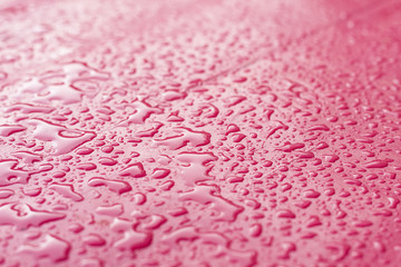 Drops of water on pink wooden background