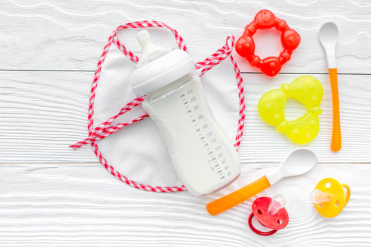 Mother care breast milk in bottle and infant formula powdered healthy food with bib for baby feeding on white background top view