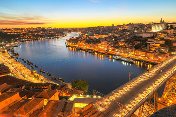 Fototapeta na wymiar Aerial view of Dom Luis I on Douro River at twilight from Miradouro da Serra do Pilar at Vila Nova de Gaia, Porto, Portugal. The iron arch bridge is icon and symbol of city. Scenic urban skyline.
