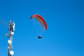 Paraglider flies in the blue sky.