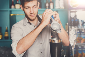 Bartender making cocktail with lime, close-up