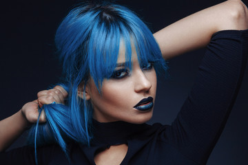 Portrait of a young woman with blue color hair