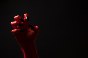 Red devil creepy halloween hand on a black background
