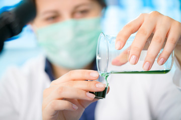 Girl laboratory assistant in the chemical laboratory of the university experiment with chemical reagents