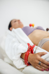 Obraz na płótnie Canvas Close up electrocardiogram equipment on woman hand. ECG testing in modern clinic.