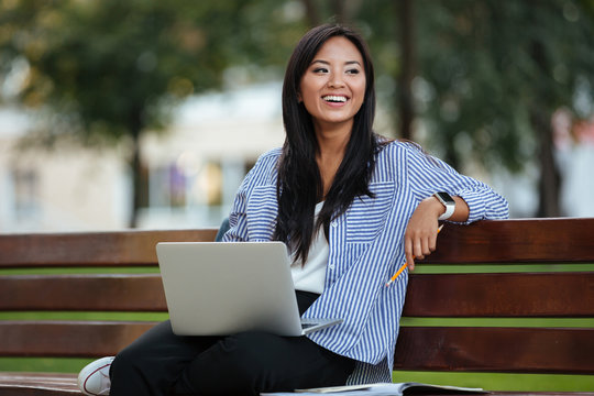 Portrait Of A Pretty Laughing Asian Female Student Sitting